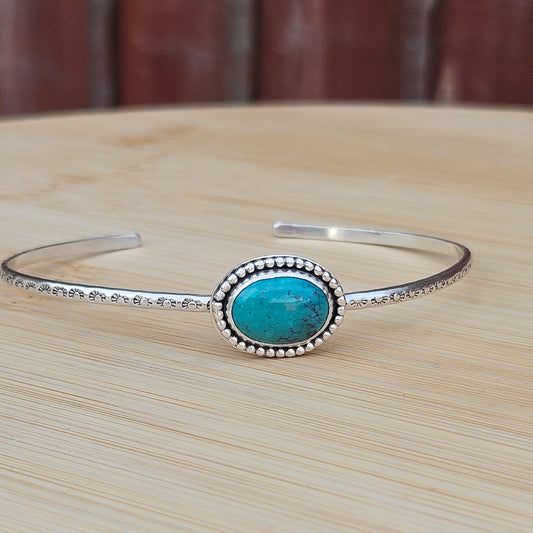 Sterling silver cuff style bangle with a turquoise